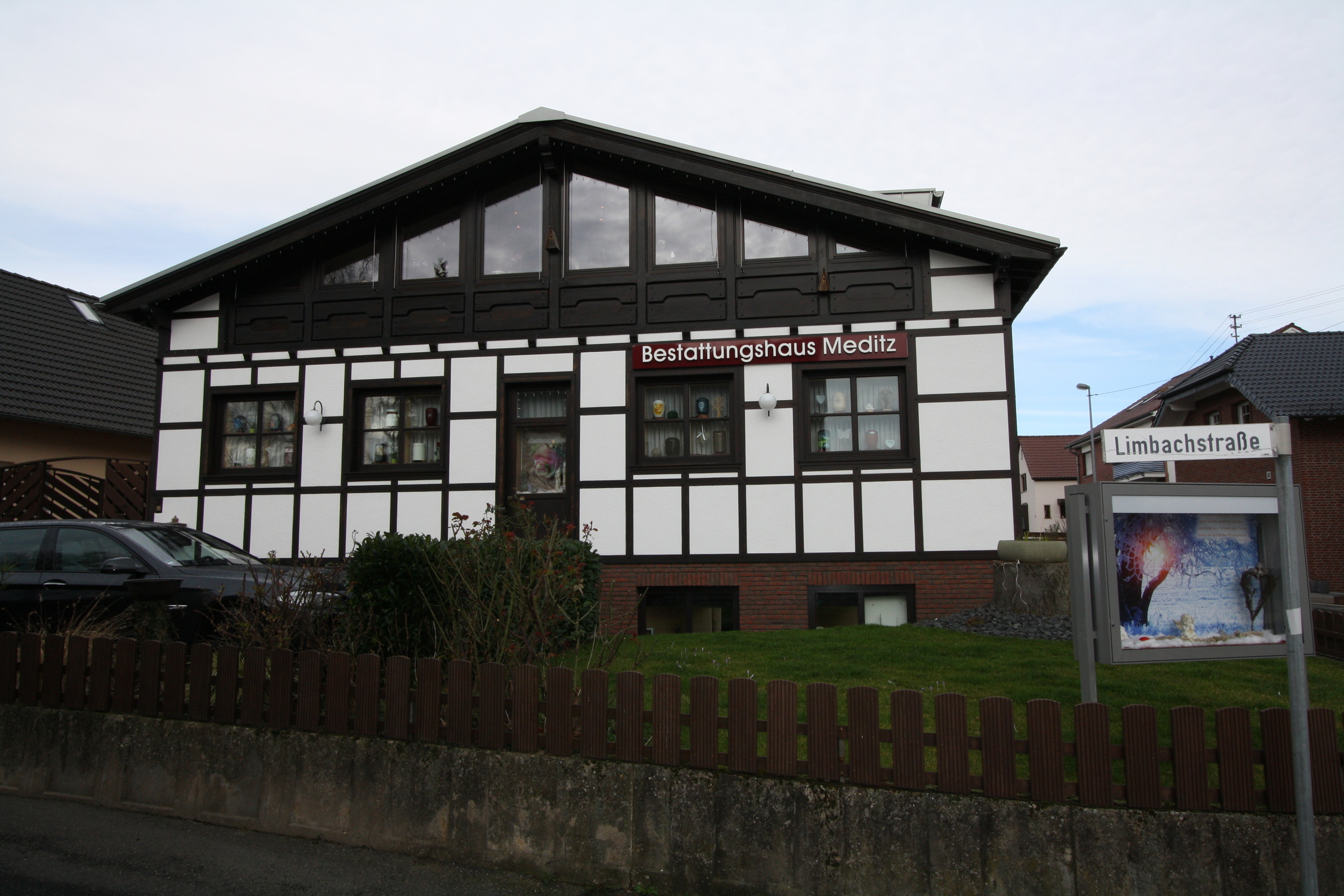 Fachwerkhaus mit dem Schild &bdquo;Bestattungshaus Meditz&ldquo; und der Stra&szlig;e &bdquo;Limbachstra&szlig;e&ldquo; im Vordergrund.